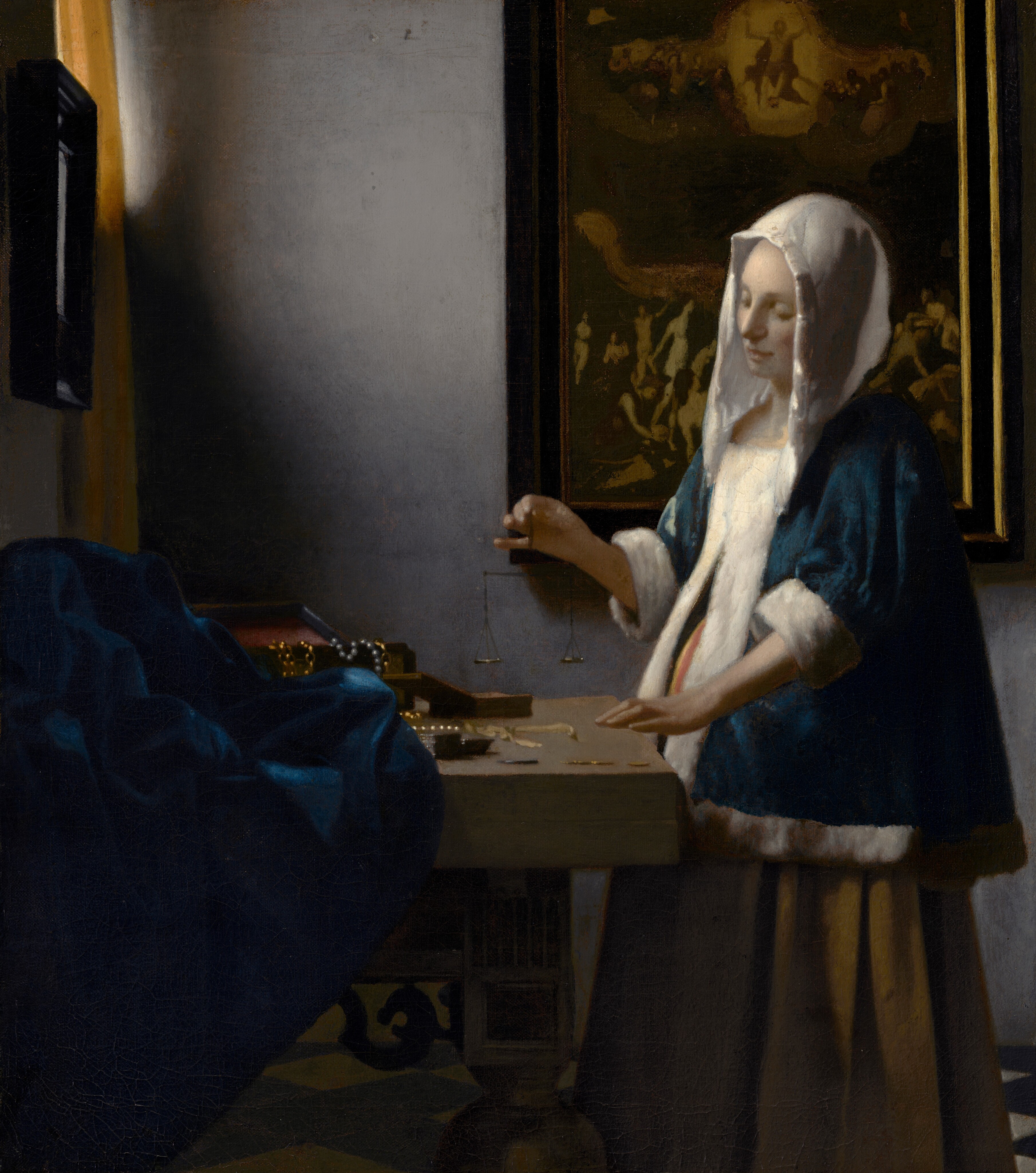 A woman quietly holds a small balance beside pearls and gold, with a painting of the Last Judgment on the wall behind her.